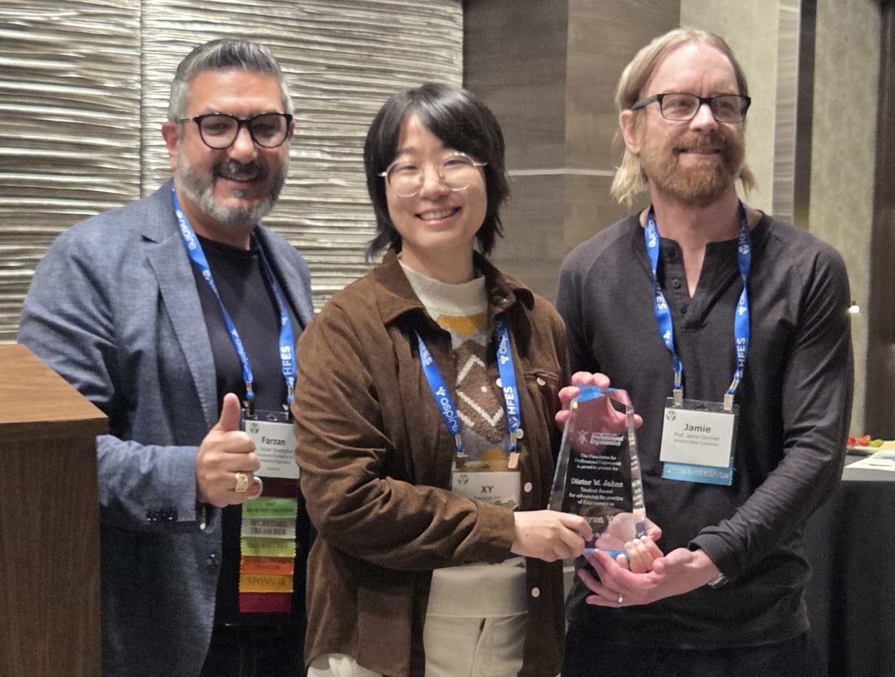 IFPE President Farzan Sasangohar (left) presents the DWJ award to Xiaoyun Yin. Professor Jamie Gorman (right) is Xiaoyun’s major professor. IFPE President Farzan Sasangohar (left) presents the DWJ award to Xiaoyun Yin. Professor Jamie Gorman (right) is Xiaoyun’s major professor.